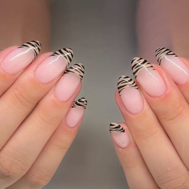 Zebra-print accent nails on a nude almond-shaped manicure